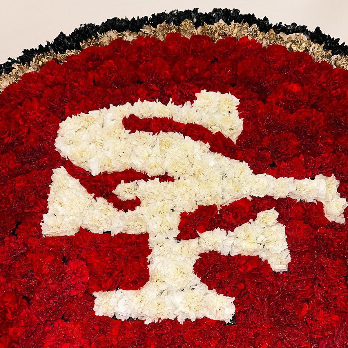 Close-up of San Francisco 49ers tribute wreath made with red and white carnations