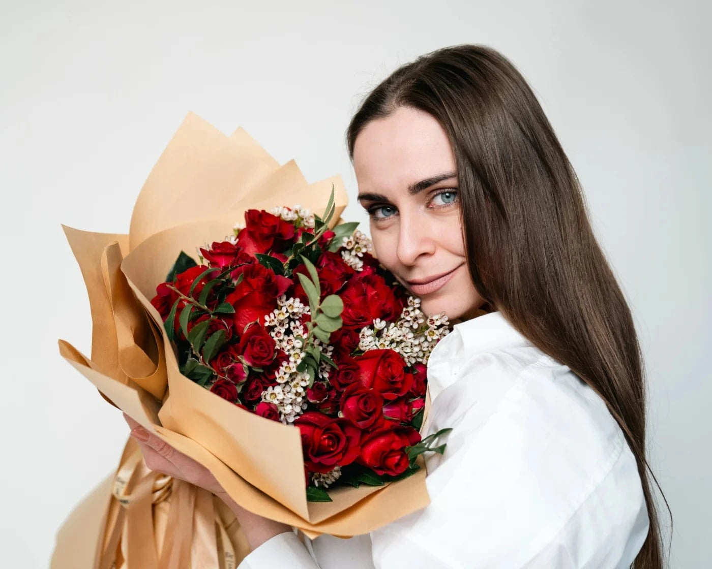 Woman holding a bouquet of red roses with white accent flowers in San Mateo – Flowers Valley flower delivery