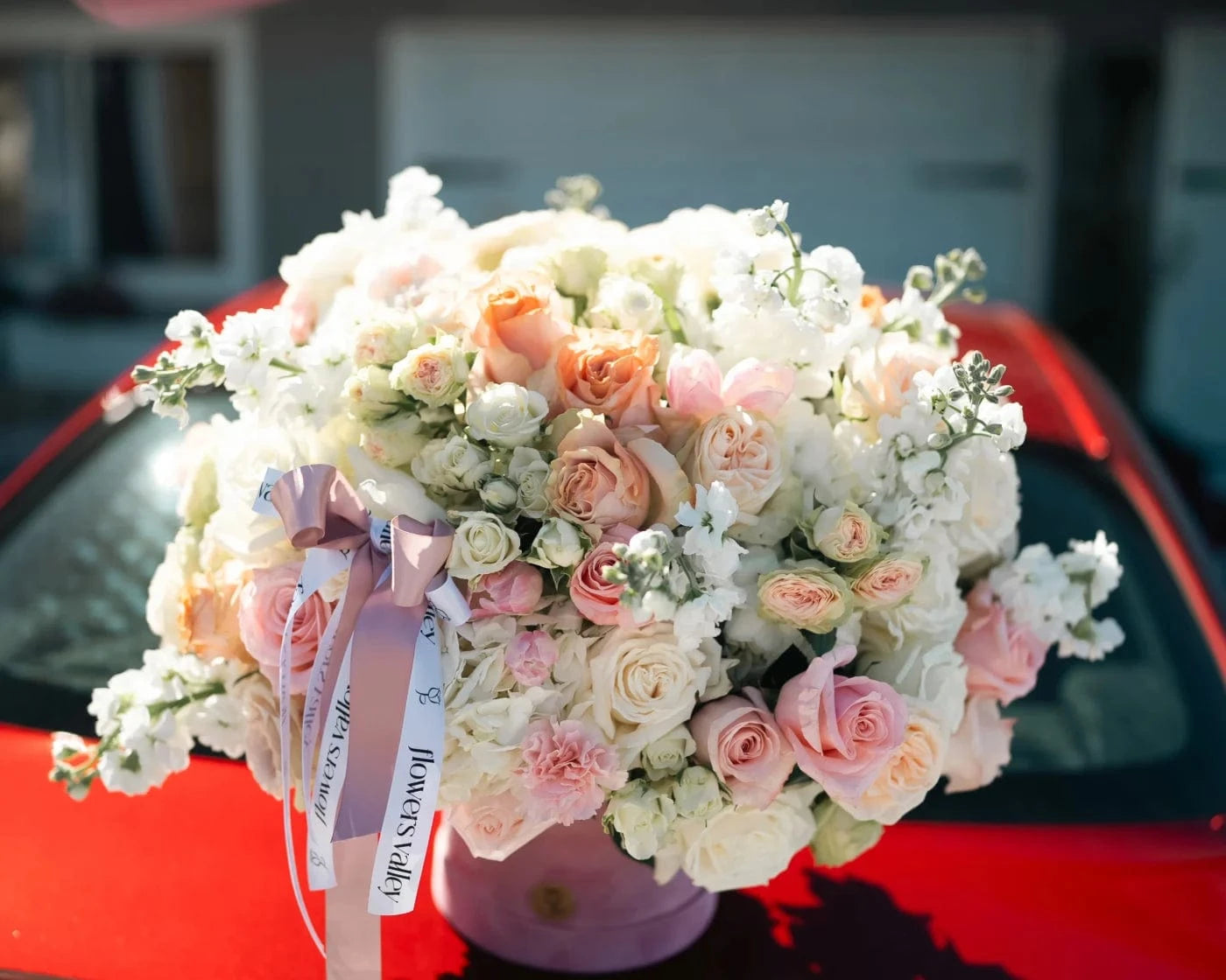 Elegant pastel bouquet with roses and hydrangeas on a car in San Rafael – Flowers Valley delivery