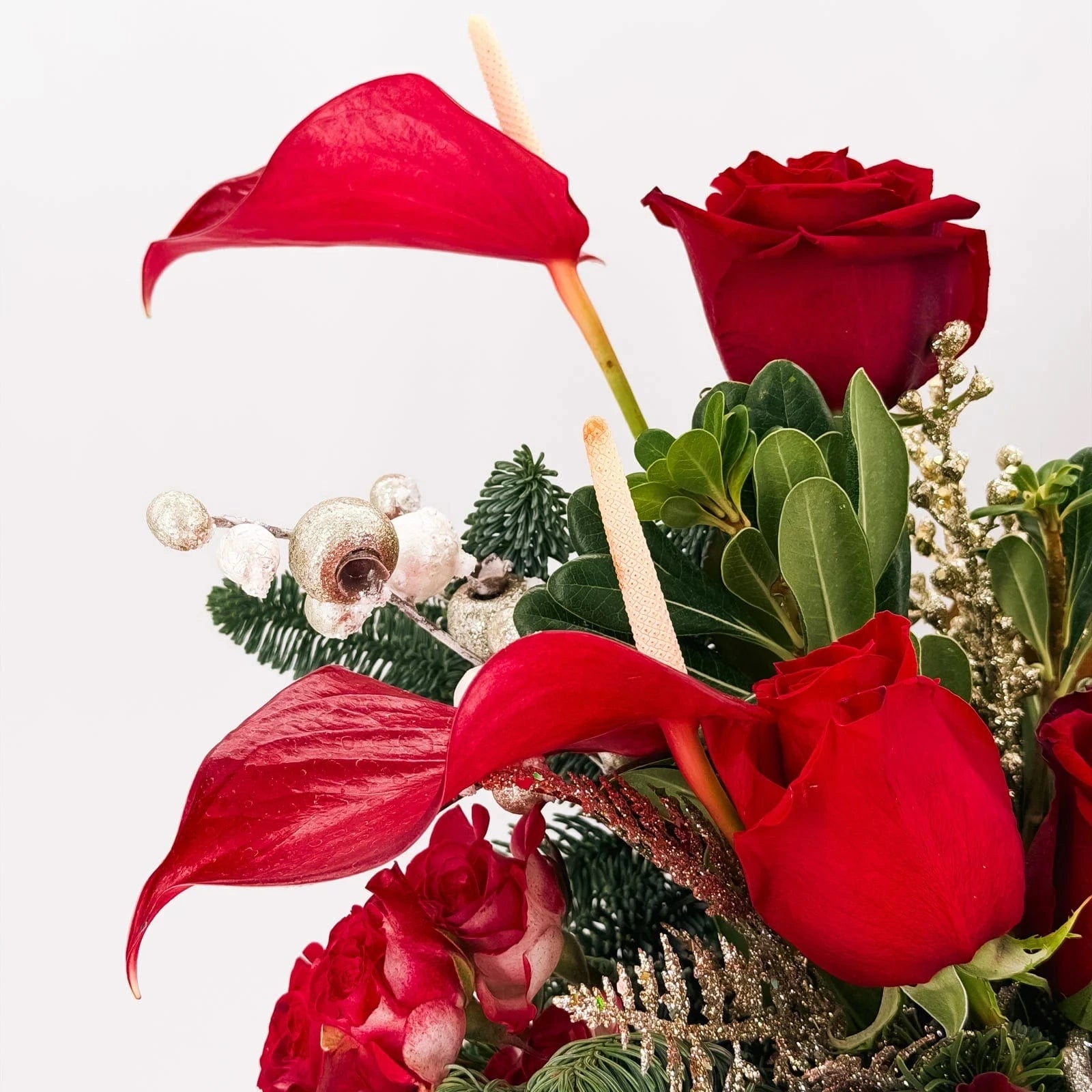 Close-up of Scarlet Lights Arrangement with red anthuriums, roses, and golden accents