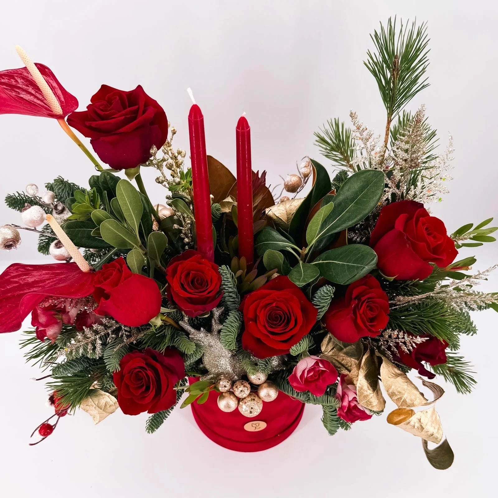 Top view of Scarlet Lights Arrangement with candles, festive roses, and holiday foliage