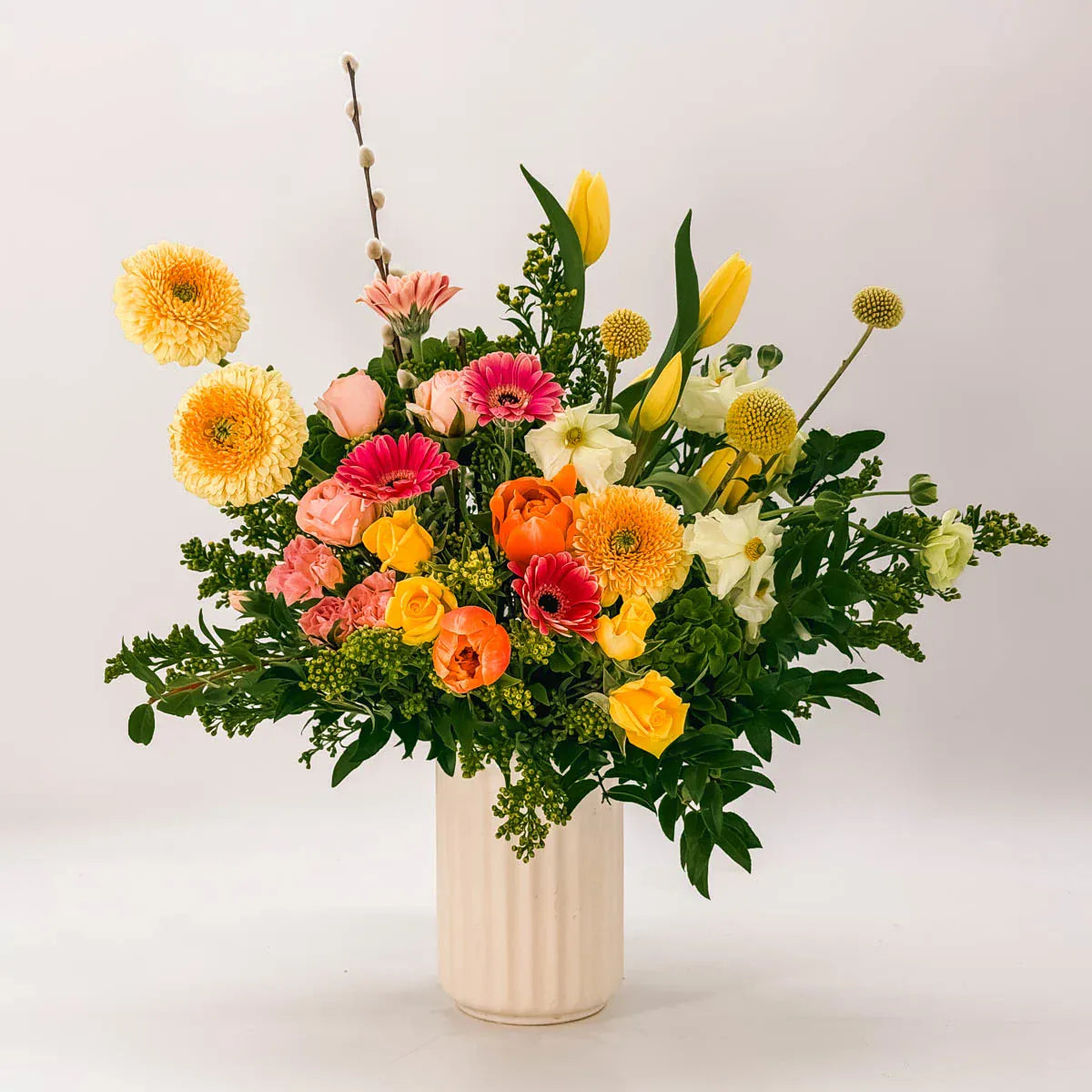 Spring Garden Easter Vase arrangement with pink gerbera daisies, orange tulips, and yellow roses in ceramic vase