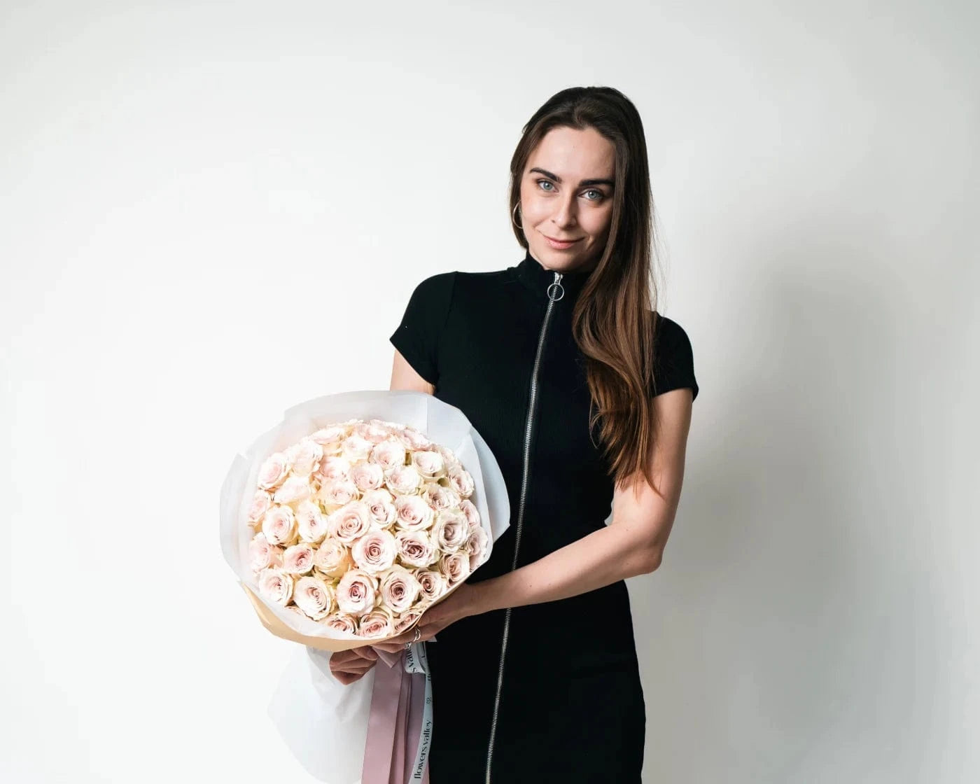 Woman holding a bouquet of rich red roses with greenery, wrapped in white paper – Flowers Valley Vallejo CA flower delivery