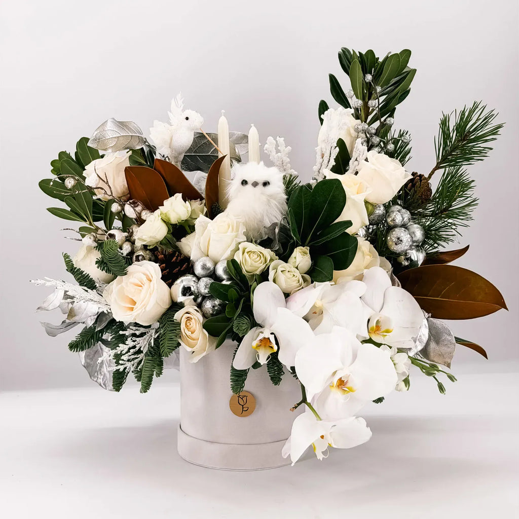 Winter Wonderland floral arrangement with white roses, orchids, and holiday accents by Flowers Valley