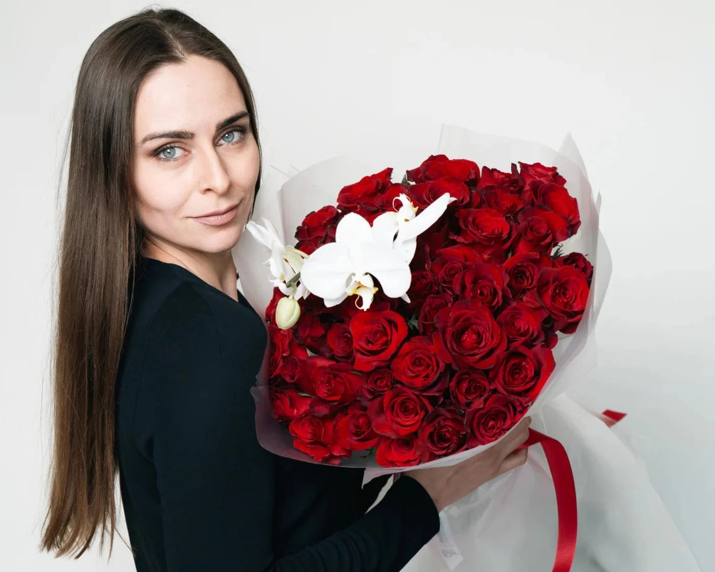 Woman holding a luxurious heart-shaped bouquet of red roses with white orchids – Flowers Valley Morgan Hill flower delivery