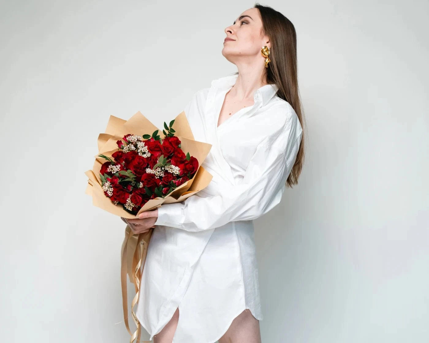 Elegant woman in a white dress holding a bouquet of red roses with white accent flowers – Flowers Valley Sebastopol flower delivery
