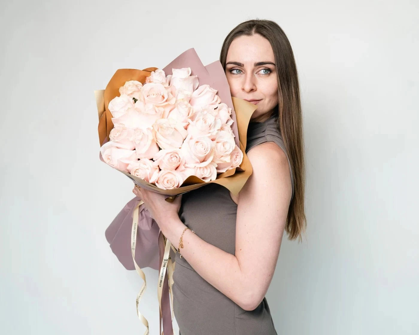 Woman holding a large bouquet of white roses wrapped in paper – Flowers Valley Rohnert Park flower delivery
