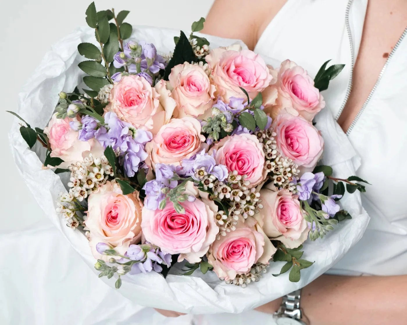 Woman smelling a bouquet of elegant white roses wrapped in pastel paper – Flowers Valley Walnut Creek flower delivery