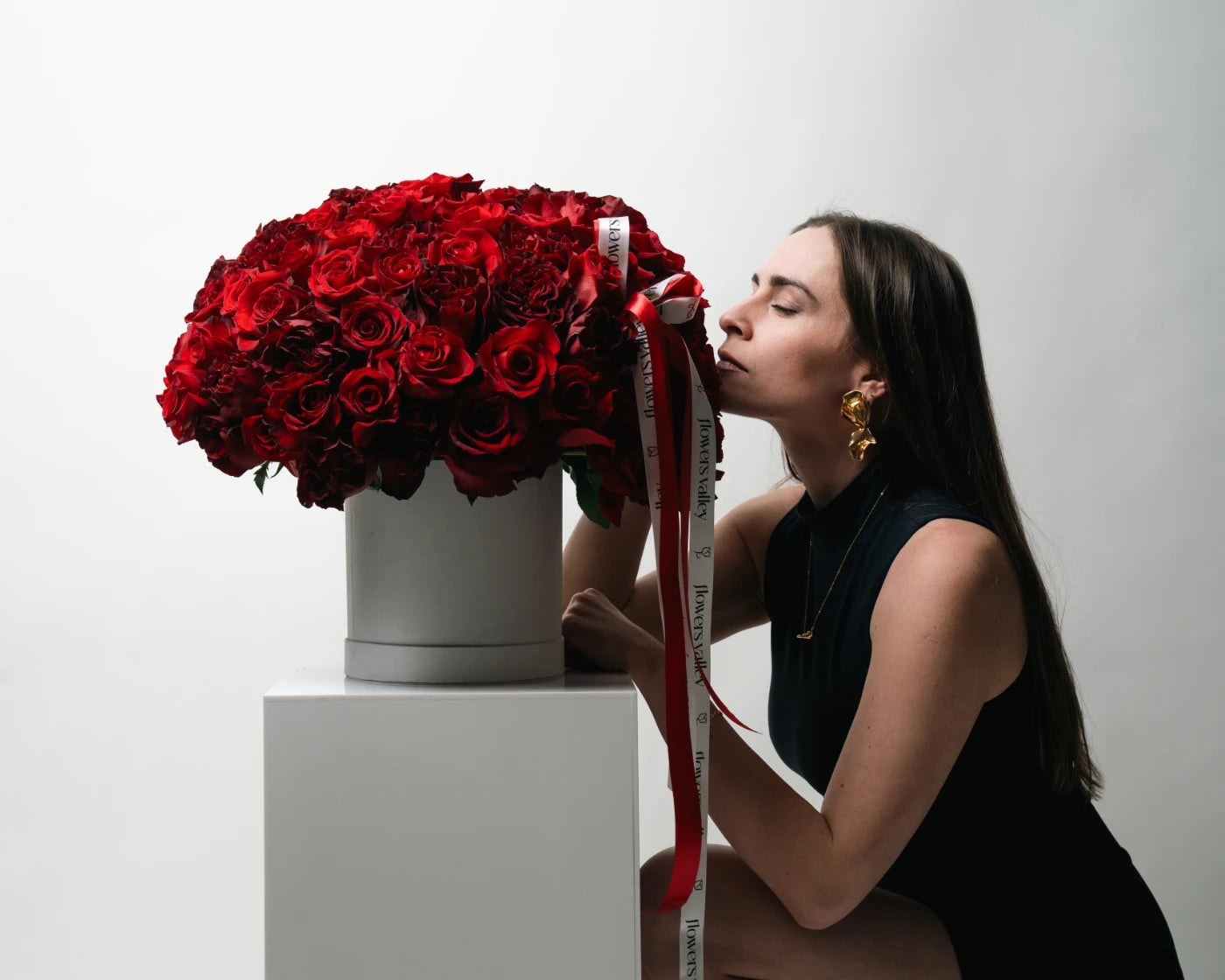 Elegant woman admiring a luxury box of deep red roses – Flowers Valley Brentwood flower delivery